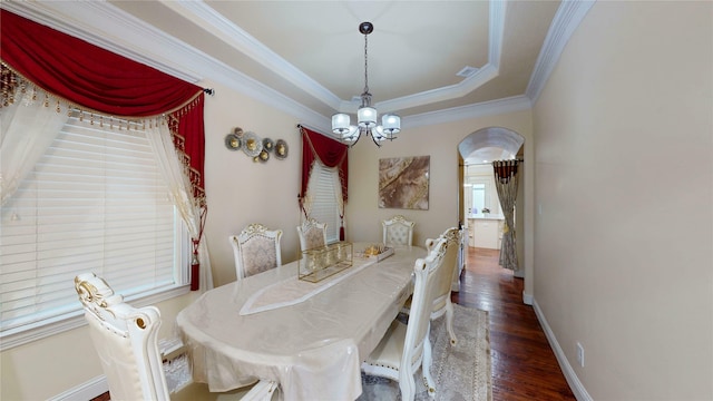 dining space featuring baseboards, arched walkways, wood finished floors, an inviting chandelier, and crown molding