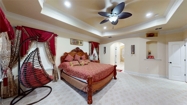 bedroom featuring arched walkways, visible vents, and a raised ceiling