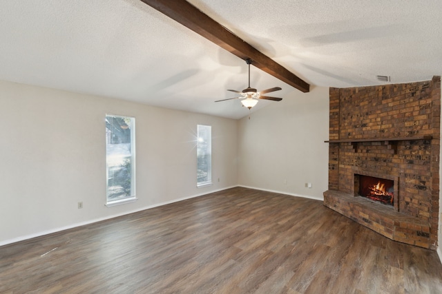 unfurnished living room featuring a textured ceiling, vaulted ceiling with beams, a fireplace, baseboards, and dark wood finished floors