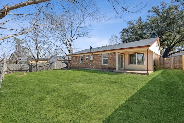 rear view of house with a patio area, a fenced backyard, a lawn, and brick siding