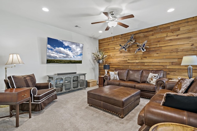 living room featuring recessed lighting, wooden walls, a ceiling fan, and light colored carpet