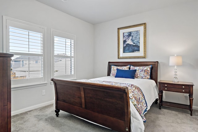 bedroom with baseboards and light colored carpet