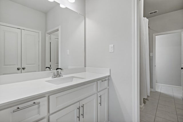 full bath with a closet, visible vents, vanity, tile patterned flooring, and baseboards