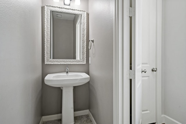 bathroom featuring a sink and baseboards