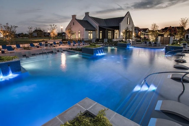 community pool with a patio area and fence