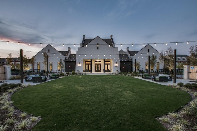 view of home's community featuring fence, a lawn, and a patio