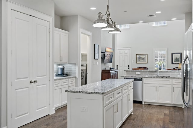 kitchen featuring visible vents, white cabinetry, appliances with stainless steel finishes, a center island, and pendant lighting