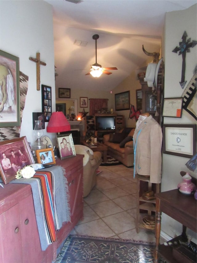 living room featuring lofted ceiling, light tile patterned floors, ceiling fan, and visible vents