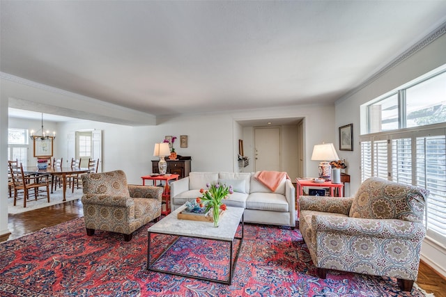 living room with crown molding and an inviting chandelier