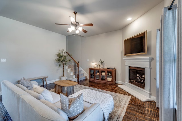 living area with a fireplace with raised hearth, ceiling fan, recessed lighting, baseboards, and stairway