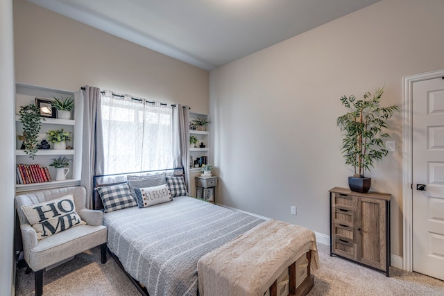 bedroom with baseboards and light colored carpet