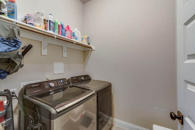 clothes washing area featuring washer and dryer, laundry area, and baseboards