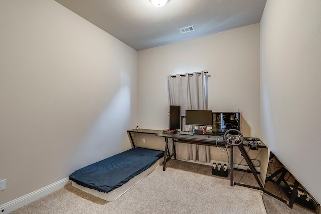 exercise room featuring baseboards, visible vents, and light colored carpet