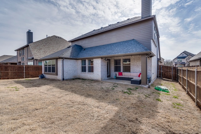 back of house featuring brick siding, roof with shingles, a chimney, and a fenced backyard