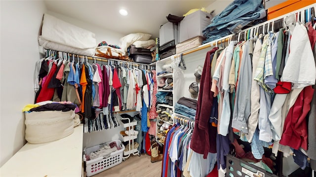 walk in closet with light wood finished floors