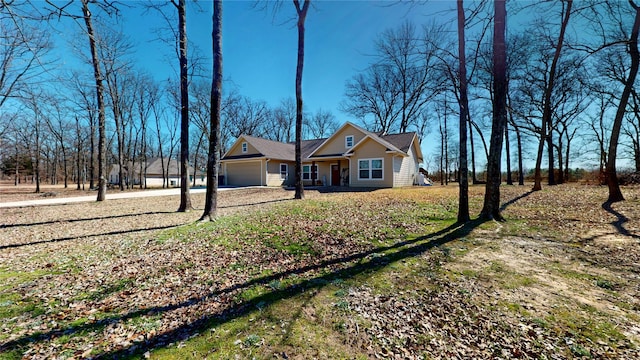 view of front of property with dirt driveway and an attached garage