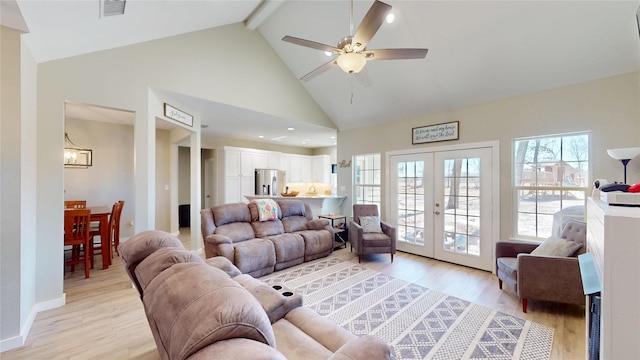 living room with light wood-type flooring, visible vents, beamed ceiling, and french doors