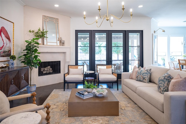 living room featuring crown molding, a wealth of natural light, a fireplace, and an inviting chandelier