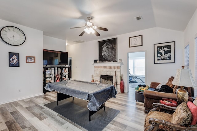 game room featuring visible vents, light wood-style flooring, pool table, vaulted ceiling, and a fireplace