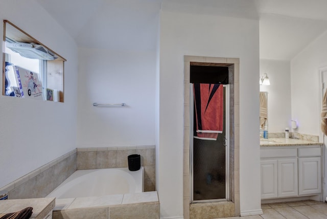 bathroom with tile patterned floors, a bath, and vanity