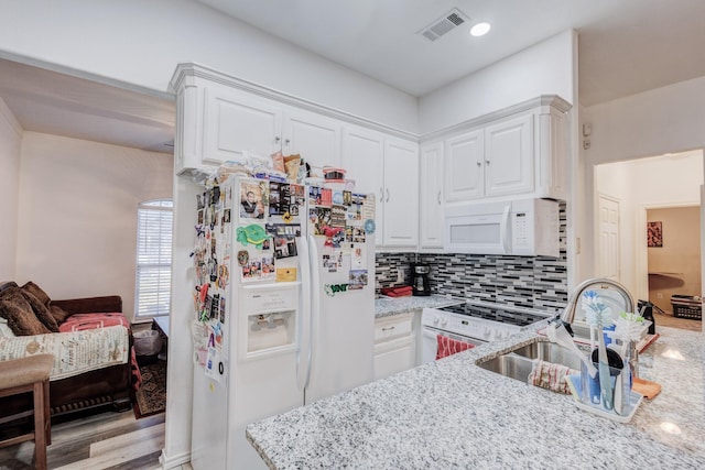 kitchen featuring light stone countertops, white appliances, visible vents, and white cabinetry