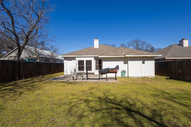 back of property featuring a lawn, a fenced backyard, a chimney, a patio area, and stucco siding