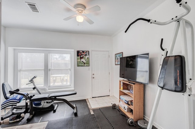 exercise area featuring baseboards, visible vents, a ceiling fan, and light tile patterned flooring