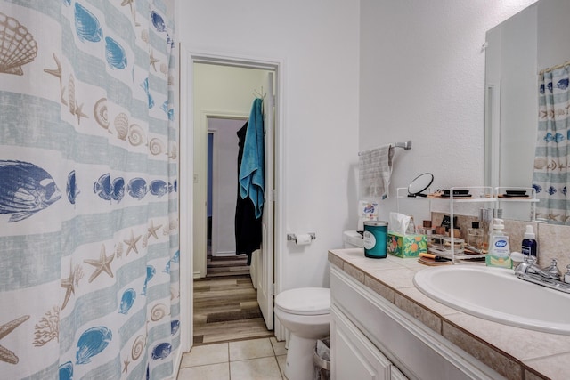 bathroom featuring vanity, tile patterned flooring, and toilet