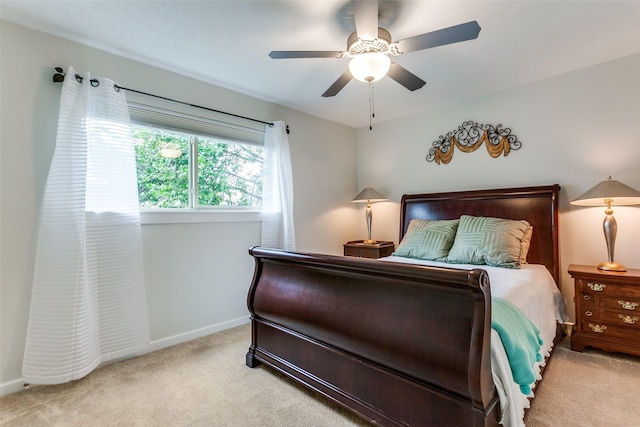 bedroom with ceiling fan, baseboards, and light colored carpet