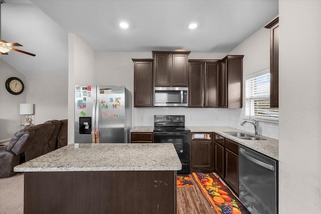 kitchen with open floor plan, appliances with stainless steel finishes, a sink, and a center island