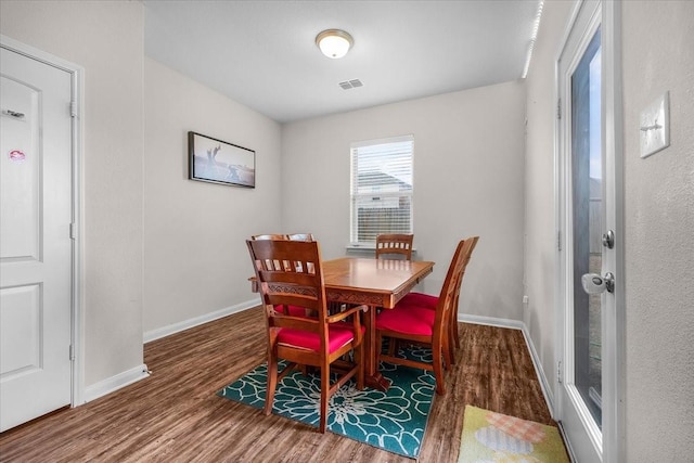 dining room featuring visible vents, baseboards, and wood finished floors