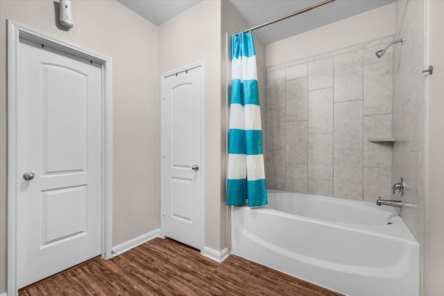 bathroom featuring shower / tub combo, wood finished floors, and baseboards