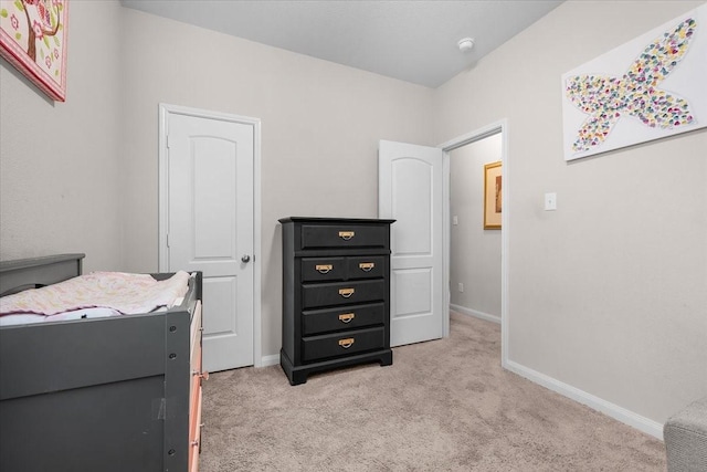 bedroom featuring light carpet and baseboards