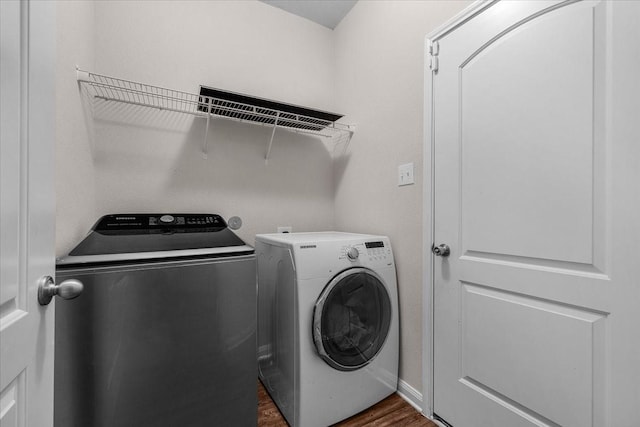 laundry area featuring laundry area, dark wood-style flooring, and washing machine and dryer