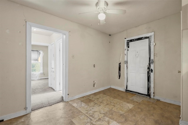 unfurnished room featuring a ceiling fan and baseboards