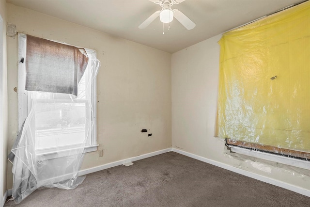 carpeted empty room with ceiling fan and baseboards