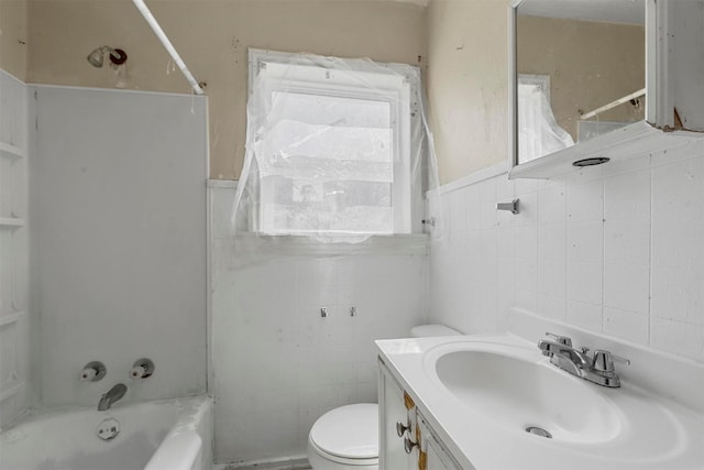 full bathroom with wainscoting, toilet, vanity, washtub / shower combination, and tile walls