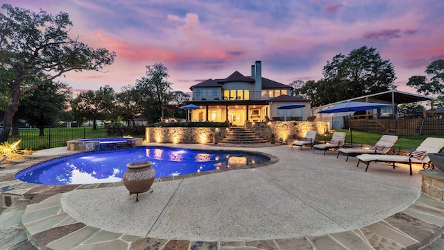 view of pool featuring a fenced backyard, a pool with connected hot tub, and a patio