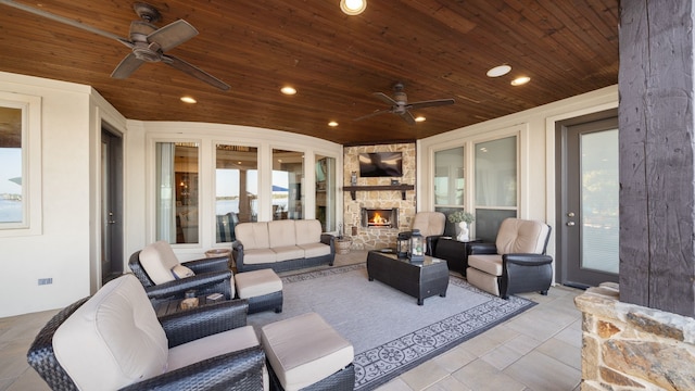 view of patio / terrace featuring ceiling fan and an outdoor living space with a fireplace