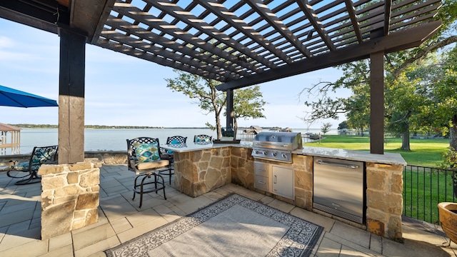 view of patio featuring grilling area, an outdoor kitchen, a water view, and a pergola