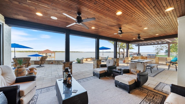 view of patio featuring a ceiling fan, outdoor dining space, a water view, and an outdoor living space