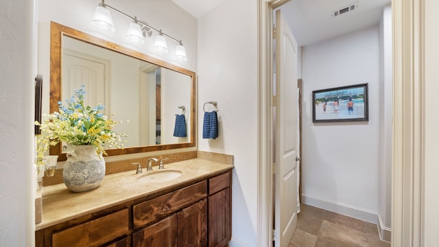 bathroom with baseboards, visible vents, and vanity