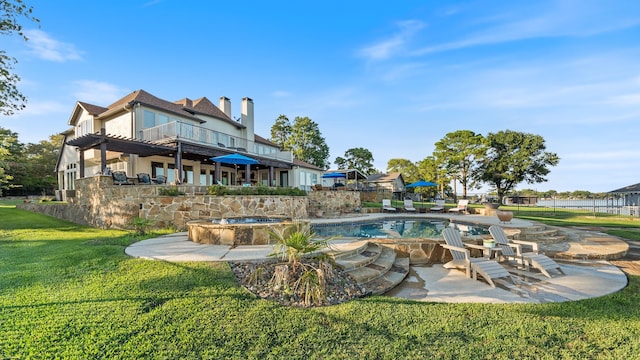 pool with an in ground hot tub, a yard, and a patio area