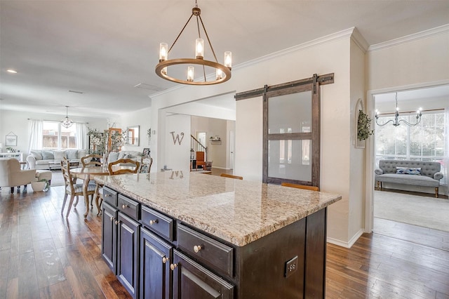 kitchen featuring a kitchen island, open floor plan, a notable chandelier, and dark brown cabinets