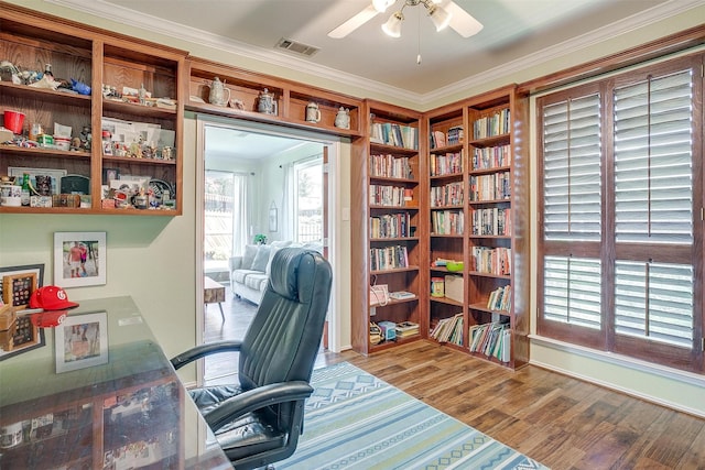 office space featuring light wood-type flooring, visible vents, crown molding, and ceiling fan