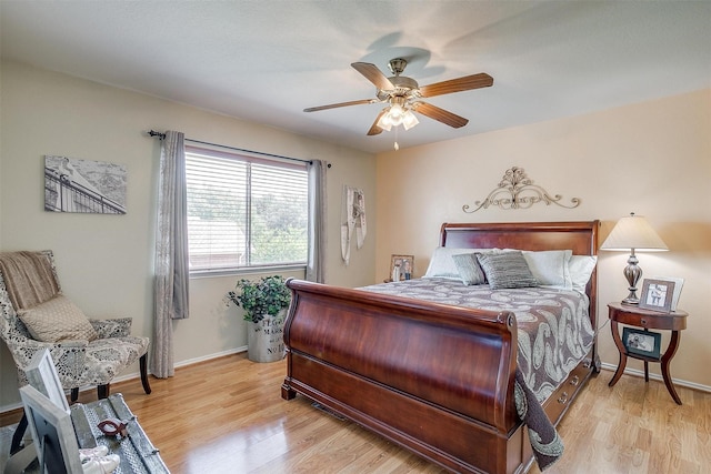 bedroom with light wood finished floors, ceiling fan, and baseboards