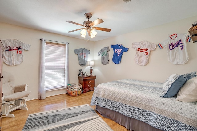 bedroom with ceiling fan, visible vents, baseboards, and wood finished floors