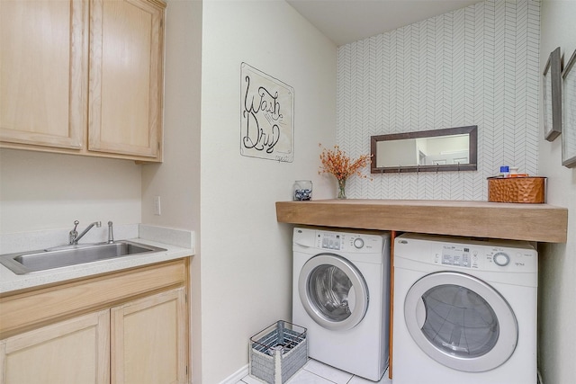 clothes washing area featuring washing machine and clothes dryer, a sink, and cabinet space