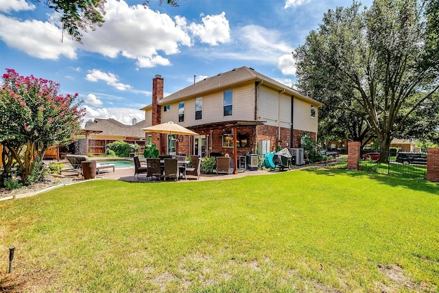 rear view of house featuring a fenced in pool, brick siding, a yard, a chimney, and fence