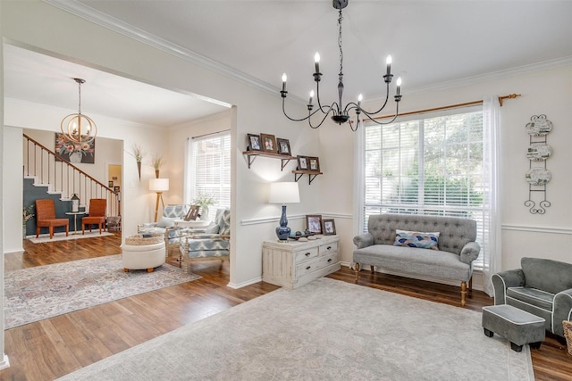 sitting room featuring ornamental molding, a healthy amount of sunlight, wood finished floors, and an inviting chandelier